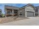 Home exterior featuring a gray garage door and stone landscaping at 1104 Brocade Dr, Littleton, CO 80126