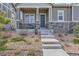 Welcoming front entrance with a charming porch, stone accents, and neat landscaping at 1104 Brocade Dr, Littleton, CO 80126