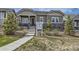 Inviting front entrance with stone accents, manicured landscaping, and a real estate sign at 1104 Brocade Dr, Littleton, CO 80126