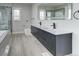 Modern bathroom with double vanity, large mirror, and frameless shower at 16521 E Easter Way, Foxfield, CO 80016