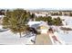 Aerial view of a snow-covered property showing front yard, driveway and surrounding landscape at 6834 Hillside Way, Parker, CO 80134