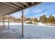 A covered patio that offers views of the backyard in winter at 6834 Hillside Way, Parker, CO 80134