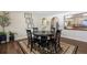 Chic dining room with black table and chairs set on a patterned rug, with view to kitchen at 6834 Hillside Way, Parker, CO 80134