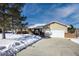 Charming ranch-style home featuring a brick facade, attached two-car garage, and snow-covered landscape at 6834 Hillside Way, Parker, CO 80134