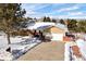 Charming ranch-style home featuring a brick facade, attached two-car garage, and snow-covered landscape at 6834 Hillside Way, Parker, CO 80134