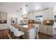 Bright kitchen with island seating, stainless appliances, white cabinets, and hardwood floors at 6834 Hillside Way, Parker, CO 80134