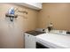 Convenient laundry room featuring modern washer and dryer with a custom mounted ironing station at 6834 Hillside Way, Parker, CO 80134