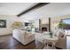 Bright living room with a brick fireplace, hardwood floors and a large window overlooking the front yard at 6834 Hillside Way, Parker, CO 80134