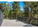 Outdoor deck with wood flooring, surrounded by trees at 10411 Dowdle Dr, Golden, CO 80403