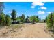 Exterior view of property with shed, blue skies, and dirt driveway at 10411 Dowdle Dr, Golden, CO 80403