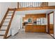 Open kitchen and living space features custom wood cabinets, and a ladder to the loft at 10411 Dowdle Dr, Golden, CO 80403