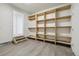 Basement storage area with built-in shelving and laminate flooring, offering ample space at 15614 E 51St Pl, Denver, CO 80239