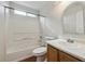 Bright bathroom featuring a shower-tub combo, a wood vanity, and an arched mirror at 15614 E 51St Pl, Denver, CO 80239