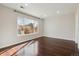 An empty bedroom with beautiful dark hardwood flooring and a large bright window at 15614 E 51St Pl, Denver, CO 80239