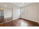 Bright bedroom with hardwood floors, closet with mirrored doors, and a window at 15614 E 51St Pl, Denver, CO 80239