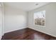 Well-lit bedroom with hardwood floors and a large window overlooking a peaceful neighborhood at 15614 E 51St Pl, Denver, CO 80239