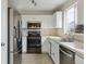 Bright kitchen featuring stainless steel appliances, white cabinetry, and neutral countertops at 15614 E 51St Pl, Denver, CO 80239