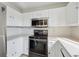 Bright kitchen featuring modern stainless steel appliances and white cabinetry at 15614 E 51St Pl, Denver, CO 80239