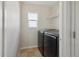 Laundry room with tile floor, a window, and modern side-by-side washer and dryer at 15614 E 51St Pl, Denver, CO 80239