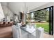 Bright dining space with glass table, views to the green backyard, and open access to the kitchen at 2500 Van Gordon St, Lakewood, CO 80215