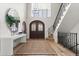 Bright foyer featuring a decorative wrought iron staircase and arched wooden front doors at 2500 Van Gordon St, Lakewood, CO 80215