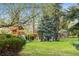 Backyard playground set surrounded by green grass and mature trees for outdoor fun at 2500 Van Gordon St, Lakewood, CO 80215