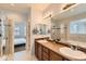 Elegant bathroom featuring double sinks, a soaking tub, and a glass-enclosed shower for a luxurious experience at 5181 Delphinium Cir, Brighton, CO 80601