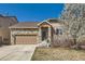Charming stone and siding home with a well-manicured lawn and a two-car garage on a sunny day at 5181 Delphinium Cir, Brighton, CO 80601