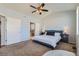 Inviting bedroom boasts a ceiling fan, ensuite bathroom access, and is furnished with side tables and lamps at 5181 Delphinium Cir, Brighton, CO 80601