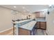 Basement bar with granite countertops, bar seating, cabinets, and a convenient under-counter refrigerator at 6302 S Jackson Gap Ct, Aurora, CO 80016