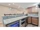 Basement bar featuring granite countertops, cabinets, stainless steel appliances, and a beverage refrigerator at 6302 S Jackson Gap Ct, Aurora, CO 80016