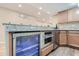 Basement bar with granite countertops, stainless steel appliances, a beverage fridge, and wood-look flooring at 6302 S Jackson Gap Ct, Aurora, CO 80016