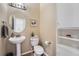 Well-lit half bathroom featuring a toilet, sink and white cabinets at 6302 S Jackson Gap Ct, Aurora, CO 80016