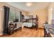 This cozy bedroom features hardwood floors, a computer desk, and a bunk bed with neutral colors at 6302 S Jackson Gap Ct, Aurora, CO 80016