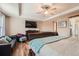 A primary bedroom features a ceiling fan, television, and a sitting area with a dark leather sofa at 6302 S Jackson Gap Ct, Aurora, CO 80016