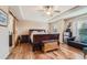 Spacious main bedroom featuring a large bed, tray ceiling and hardwood floors at 6302 S Jackson Gap Ct, Aurora, CO 80016