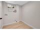 A small, bright laundry room with wood-look floors and connections for a washer and dryer at 10930 W Tulane Ave, Littleton, CO 80127