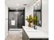 Modern bathroom features stylish vanity, updated lighting, and a shower-tub combination with glass enclosure at 4227 Mariposa St, Denver, CO 80211