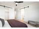 Bright bedroom featuring barn door closet, ceiling fan, and ensuite bathroom, offering modern comfort at 4227 Mariposa St, Denver, CO 80211