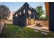 Modern home exterior with a rooftop deck, dark siding, and a well-maintained lawn at 4227 Mariposa St, Denver, CO 80211