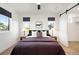 Well-lit bedroom with large windows, modern lighting, and a barn door entrance to the ensuite bathroom at 4227 Mariposa St, Denver, CO 80211