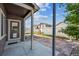 A view of the covered back porch and fenced backyard featuring a stone patio and new landscaping at 2431 Nicholson St, Berthoud, CO 80513