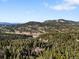 Expansive mountain landscape featuring lush green forests and rolling hills under a sunny sky at 11724 Little Turtle Ln, Conifer, CO 80433