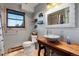 Bathroom features a unique basin sink, gray walls, and wood trim around the window at 11724 Little Turtle Ln, Conifer, CO 80433