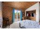Bedroom with wood ceiling, balcony access, wood accent wall, and closet at 11724 Little Turtle Ln, Conifer, CO 80433