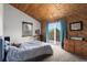 Bedroom features wood ceiling, balcony access, and dresser at 11724 Little Turtle Ln, Conifer, CO 80433