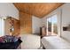 Cozy bedroom with wood ceiling, rock climbing wall, and balcony access at 11724 Little Turtle Ln, Conifer, CO 80433