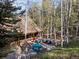 Beautiful shot of the home nestled amongst a forest of trees, featuring an expansive patio at 11724 Little Turtle Ln, Conifer, CO 80433