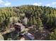 Two story cabin featuring a second story balcony surrounded by a dense pine forest at 11724 Little Turtle Ln, Conifer, CO 80433