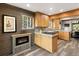 Charming kitchen with wood cabinets, stone backsplash, island, and cozy fireplace at 11724 Little Turtle Ln, Conifer, CO 80433